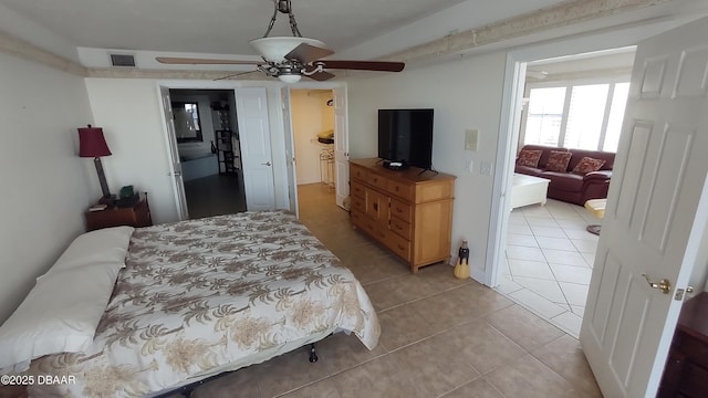 bedroom featuring a ceiling fan, visible vents, and light tile patterned floors