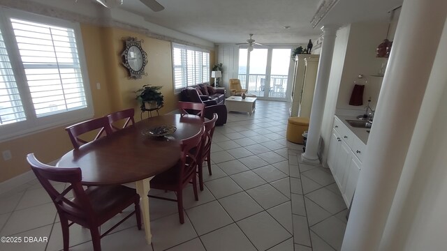 dining room with light tile patterned flooring, decorative columns, and ceiling fan