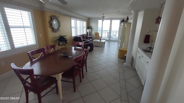 dining room featuring light tile patterned floors, decorative columns, and ceiling fan