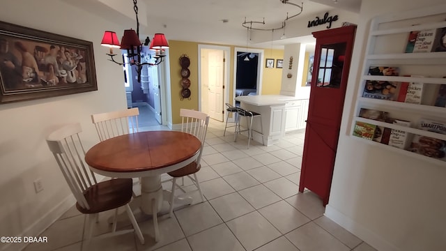 dining area with light tile patterned floors, baseboards, and an inviting chandelier