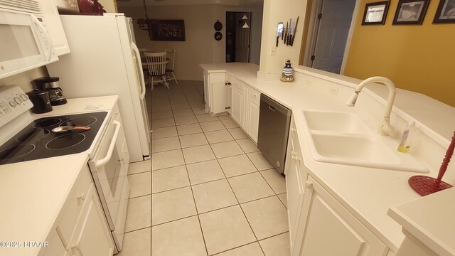 kitchen with white appliances, white cabinets, light countertops, a sink, and light tile patterned flooring