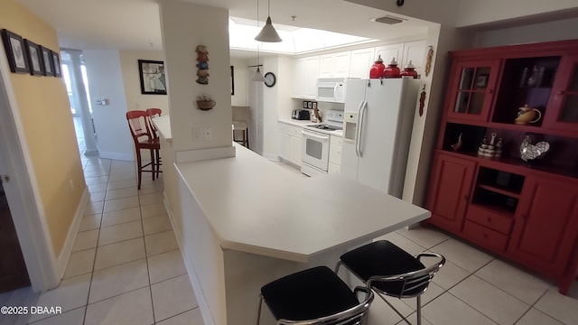 kitchen with white cabinets, white appliances, visible vents, and light tile patterned flooring