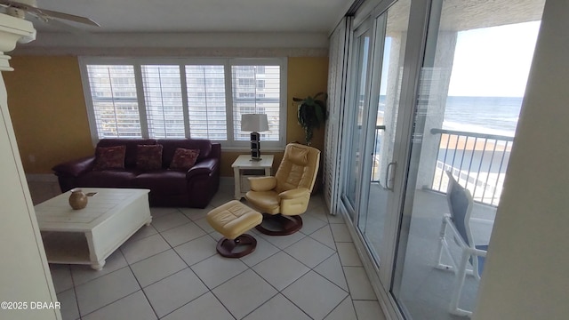 living room featuring a water view and light tile patterned floors