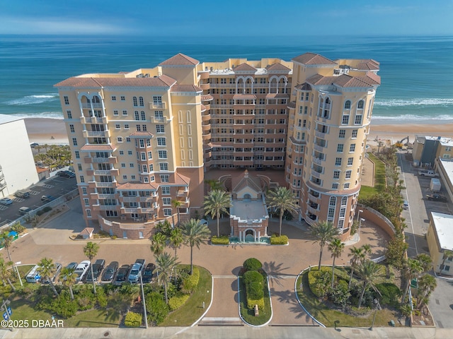 view of building exterior with a water view and a beach view