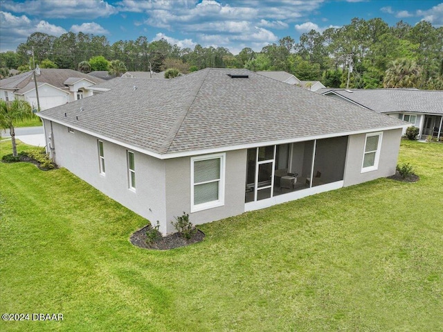 back of property featuring a sunroom and a lawn