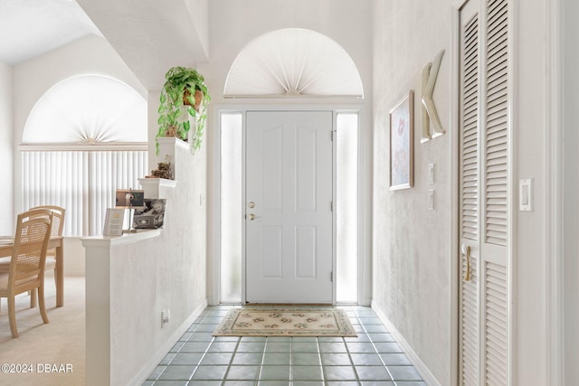 entryway featuring vaulted ceiling and tile patterned flooring