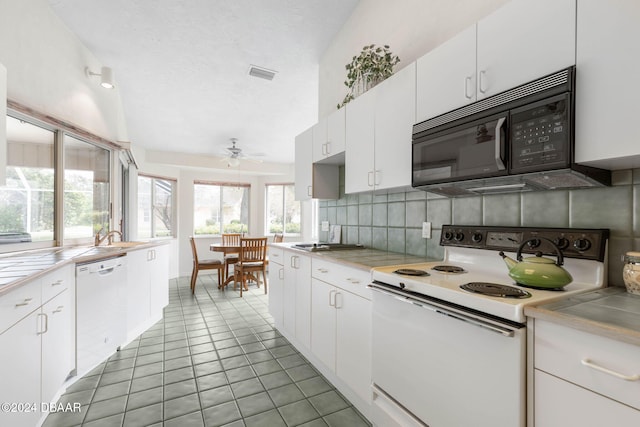 74 Kingsley Ln, Ormond Beach, FL 32174 - kitchen featuring white appliances, decorative backsplash, ceiling fan, white cabinetry, and tile counters