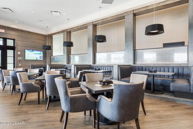 dining room with wooden walls and light wood-type flooring