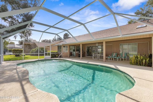 view of swimming pool featuring a patio, ceiling fan, and glass enclosure