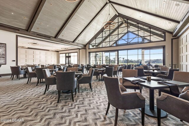 carpeted dining space featuring high vaulted ceiling, beamed ceiling, and wooden ceiling