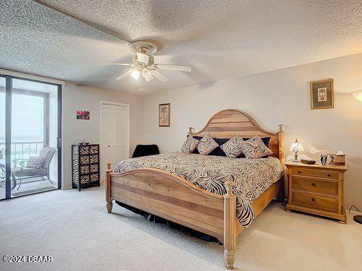 carpeted bedroom featuring ceiling fan, a textured ceiling, a closet, and access to outside