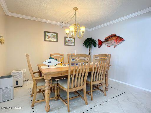 dining room with a chandelier, a textured ceiling, and crown molding