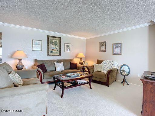 carpeted living room featuring ornamental molding and a textured ceiling