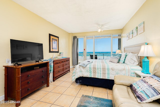 bedroom with access to outside, a water view, light tile patterned floors, and ceiling fan