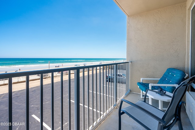 balcony featuring a beach view and a water view