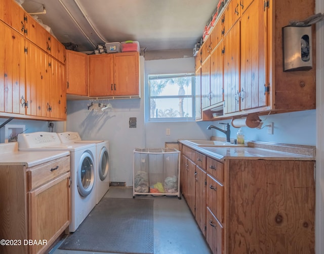 washroom with cabinets, sink, and independent washer and dryer