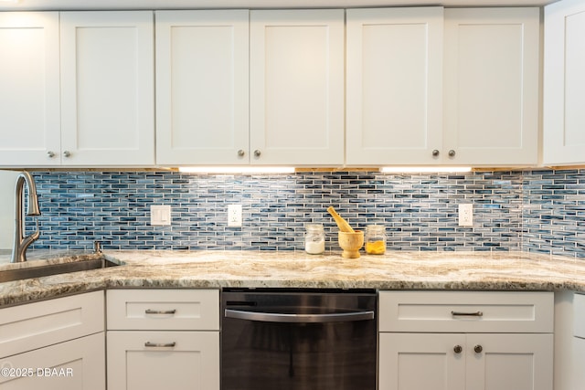 kitchen with white cabinetry, light stone countertops, black dishwasher, and sink