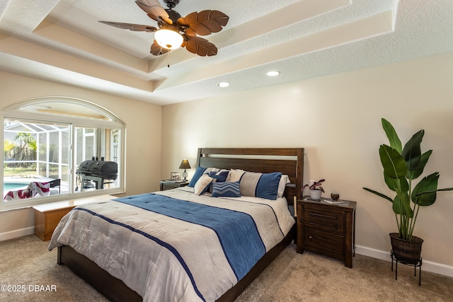 bedroom with ceiling fan, light colored carpet, a raised ceiling, and a textured ceiling