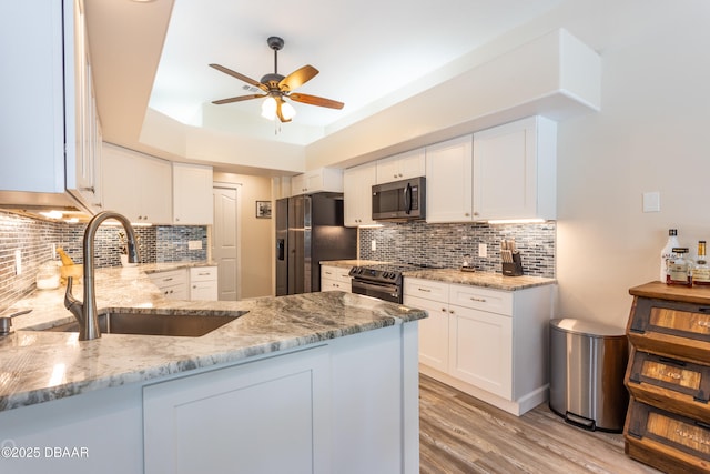 kitchen featuring sink, light stone counters, stainless steel fridge with ice dispenser, electric range oven, and white cabinets