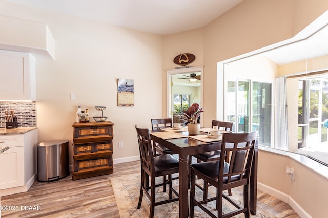 dining space with ceiling fan and light wood-type flooring