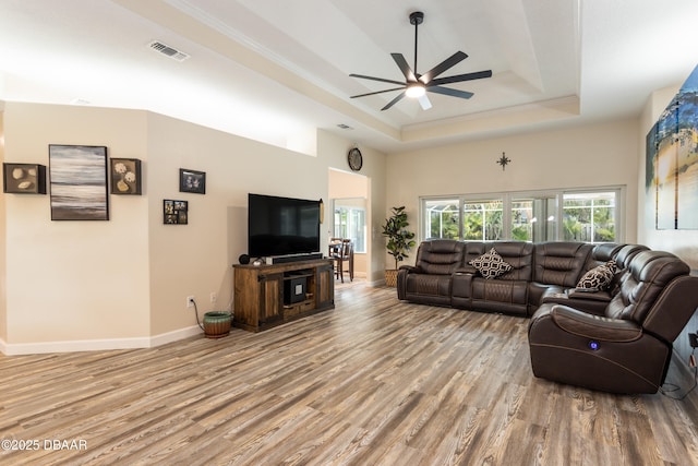 living room featuring ornamental molding, hardwood / wood-style floors, ceiling fan, and a tray ceiling