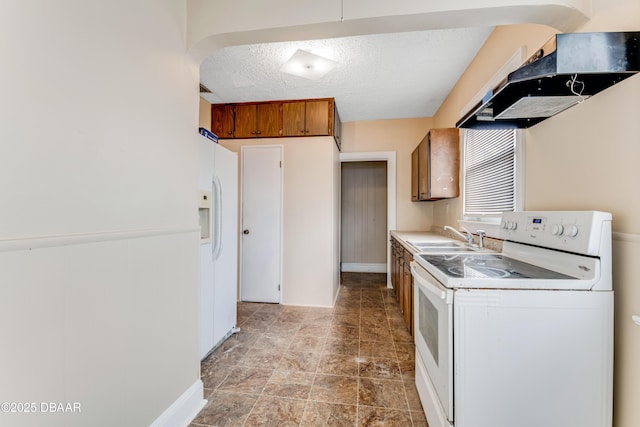 kitchen with sink, white appliances, and a textured ceiling