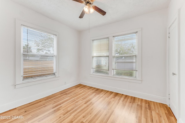 empty room featuring ceiling fan, light hardwood / wood-style flooring, and a textured ceiling