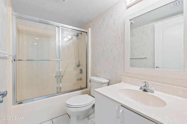 4 Oceans W Blvd Unit 306B, Daytona Beach, FL 32118 - bathroom featuring wallpapered walls, vanity, toilet, bath / shower combo with glass door, and tile patterned floors