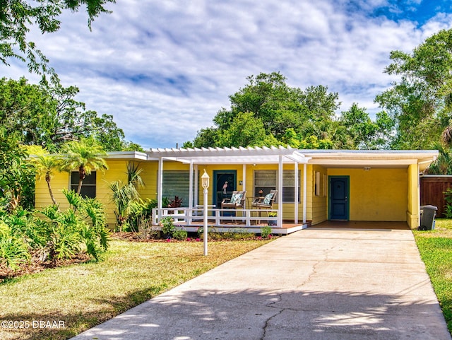 46 Reynolds Ave, Ormond Beach, FL 32174 - single story home with a porch, concrete driveway, a front yard, and a carport