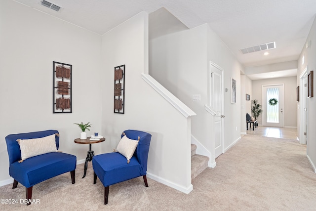 sitting room featuring light colored carpet