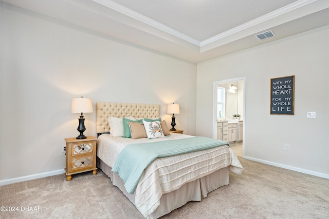 bedroom featuring light colored carpet, ornamental molding, and ensuite bath