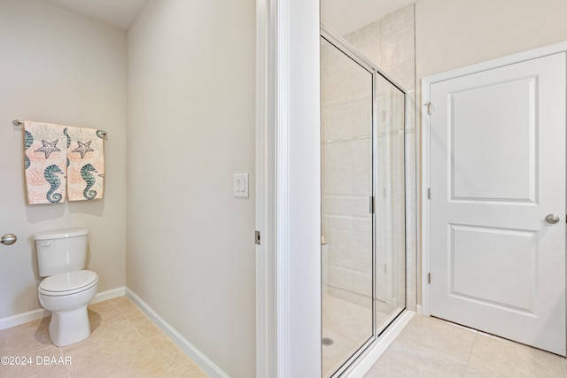 bathroom featuring tile patterned flooring, toilet, and an enclosed shower