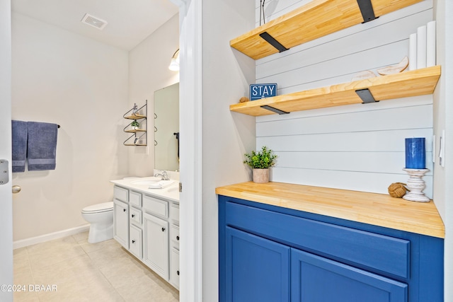 bathroom with tile patterned flooring, vanity, and toilet