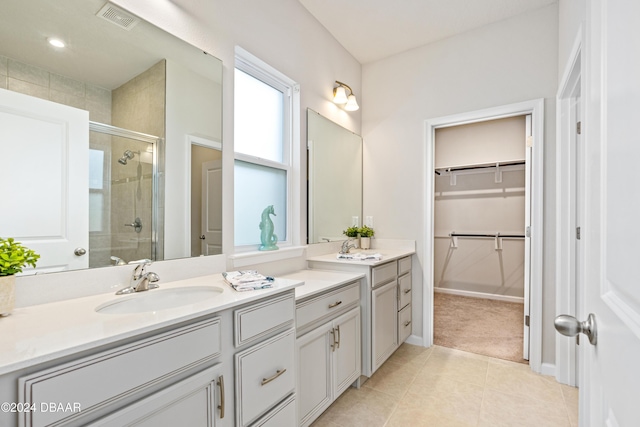 bathroom with tile patterned floors, vanity, and walk in shower