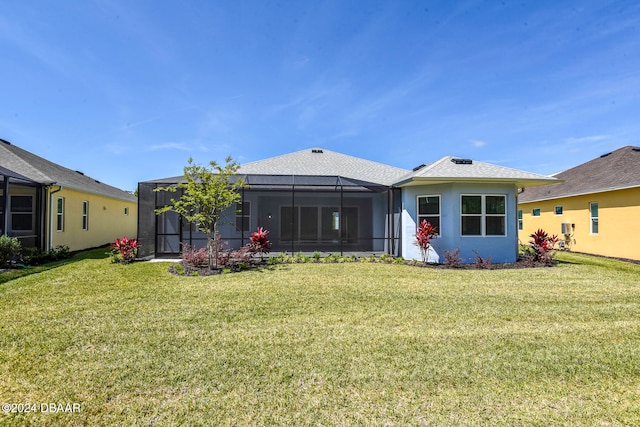 back of property with glass enclosure and a yard