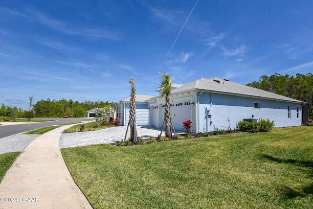 view of side of property featuring a lawn and a garage