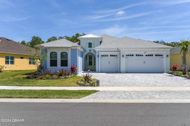 view of front of house featuring a garage and a front lawn