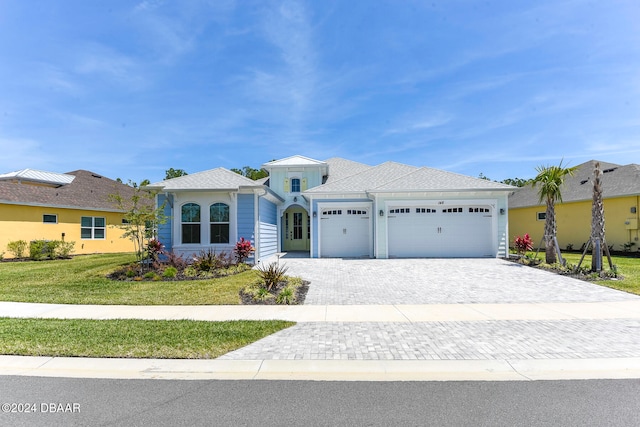 view of front of home with a front yard and a garage