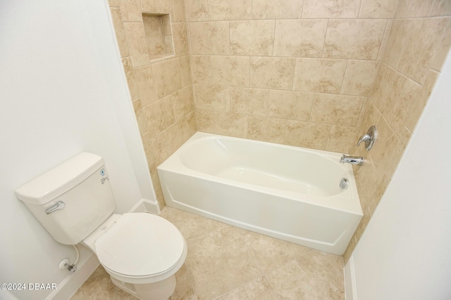 bathroom featuring tile patterned floors, toilet, and tiled shower / bath