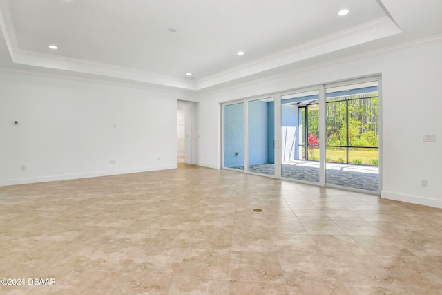 unfurnished room featuring ornamental molding and a tray ceiling