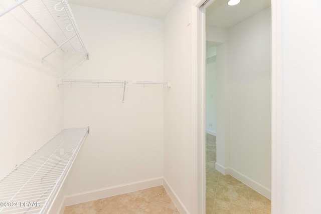 walk in closet with light tile patterned floors