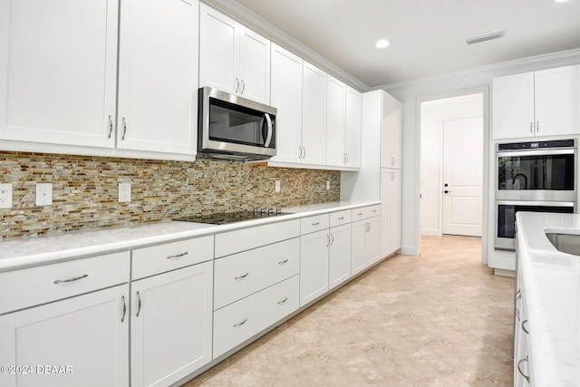 kitchen with backsplash, crown molding, white cabinets, and stainless steel appliances