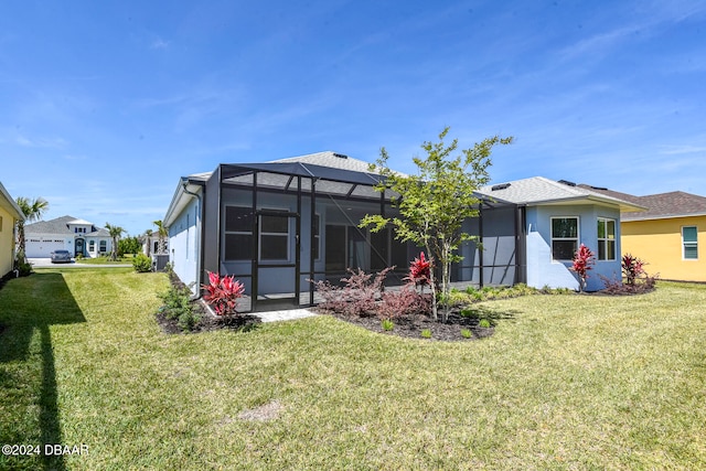 back of house with a yard and glass enclosure