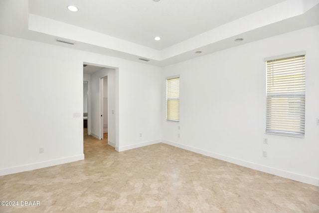 unfurnished room featuring a tray ceiling