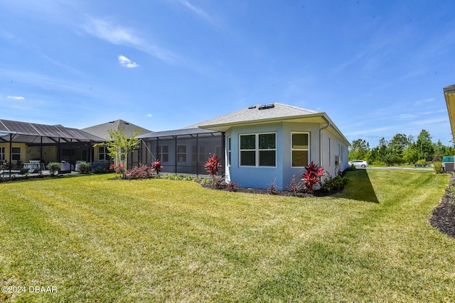 exterior space featuring a lawn and glass enclosure