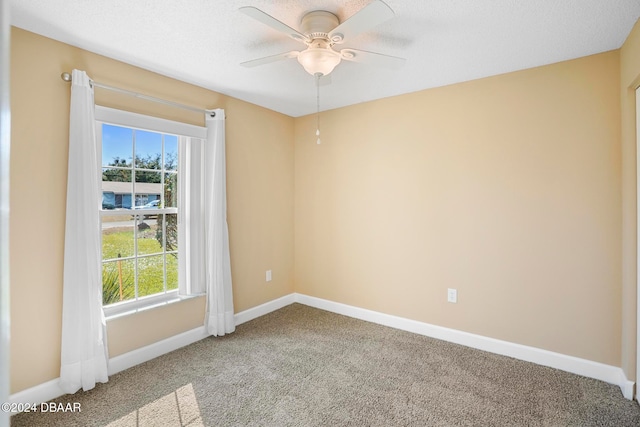 unfurnished room featuring carpet flooring, ceiling fan, and a textured ceiling