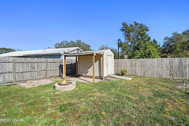 view of yard featuring a shed and a fire pit