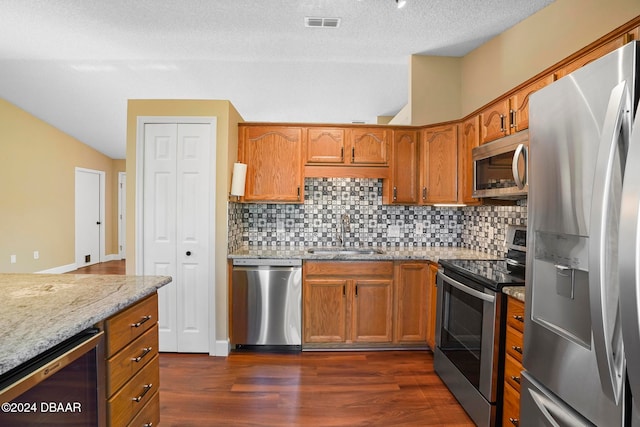 kitchen with sink, wine cooler, dark hardwood / wood-style floors, light stone countertops, and appliances with stainless steel finishes