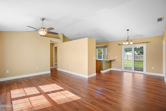 unfurnished living room with a textured ceiling, ceiling fan with notable chandelier, dark wood-type flooring, and lofted ceiling