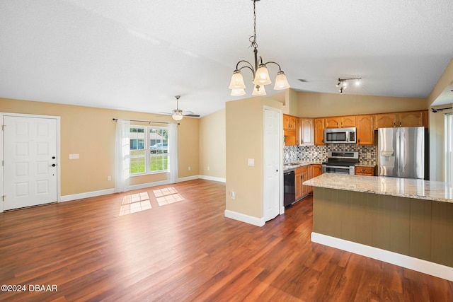 kitchen with pendant lighting, ceiling fan with notable chandelier, stainless steel appliances, and dark wood-type flooring